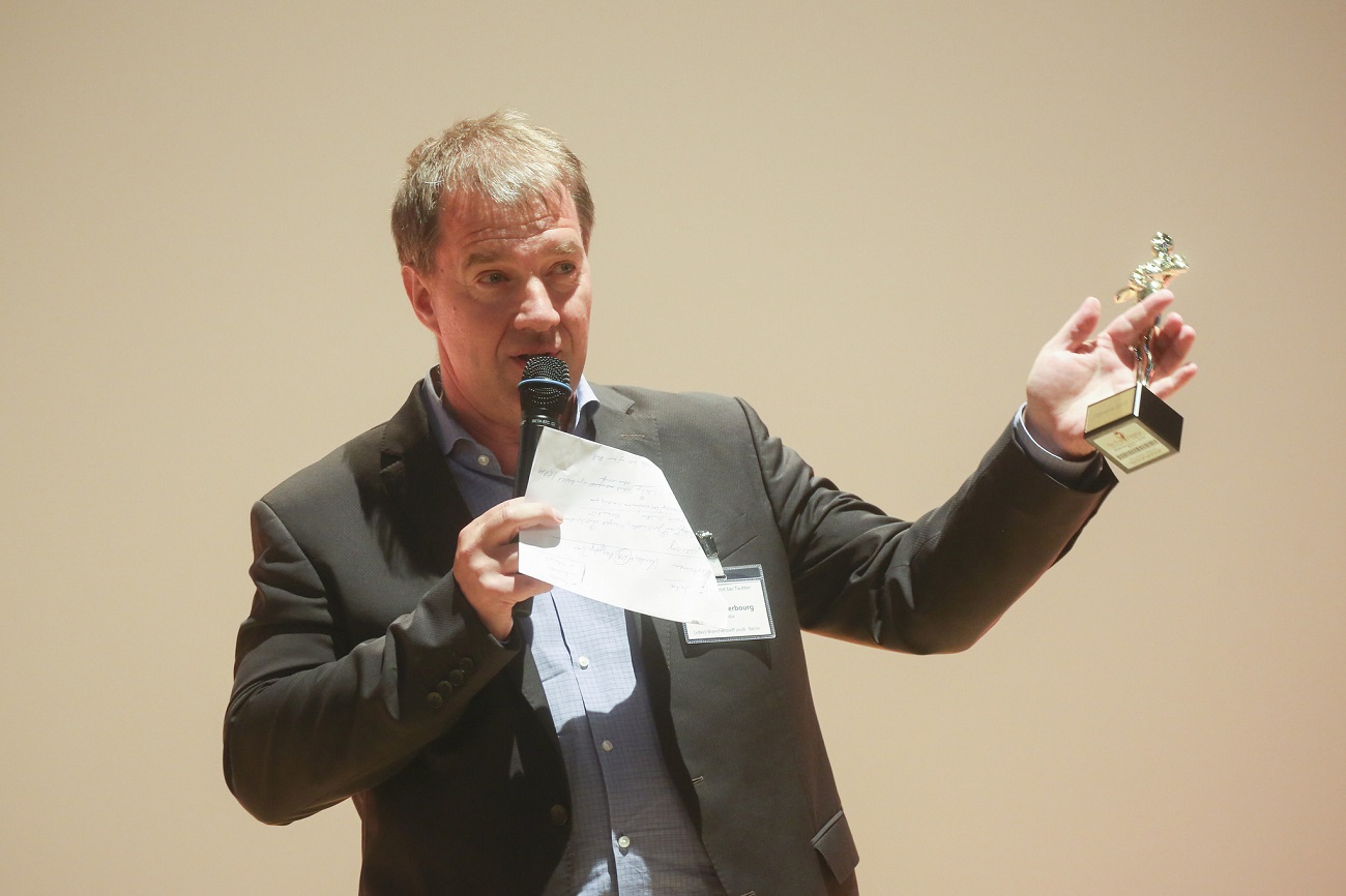 Geschäftsführer der IT2media der eine Rede hält, mit einem Preis in der Hand