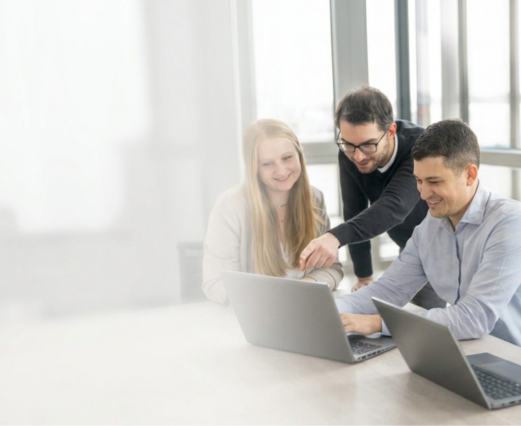 IT2media-Mitarbeitende im gemeinsamen Austausch in einem Büro