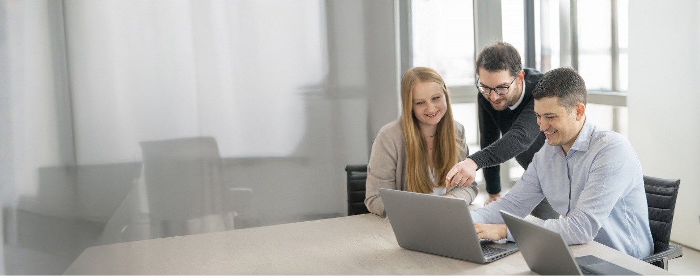 IT2media-Mitarbeitende im gemeinsamen Austausch in einem Büro